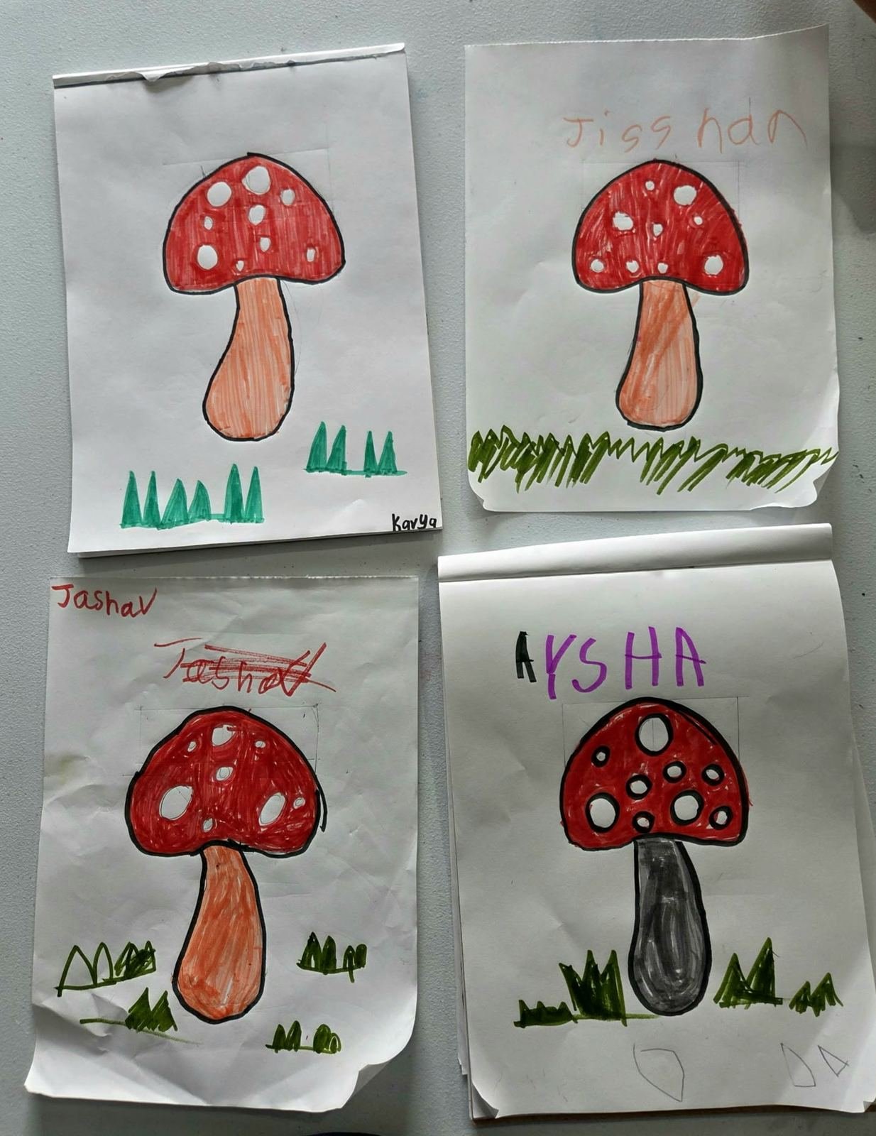Students coloring mushroom drawings at the studio table